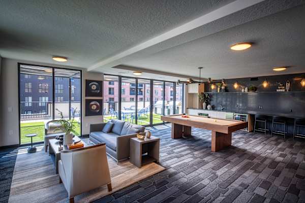 A modern living room with a pool table and a view of the city.